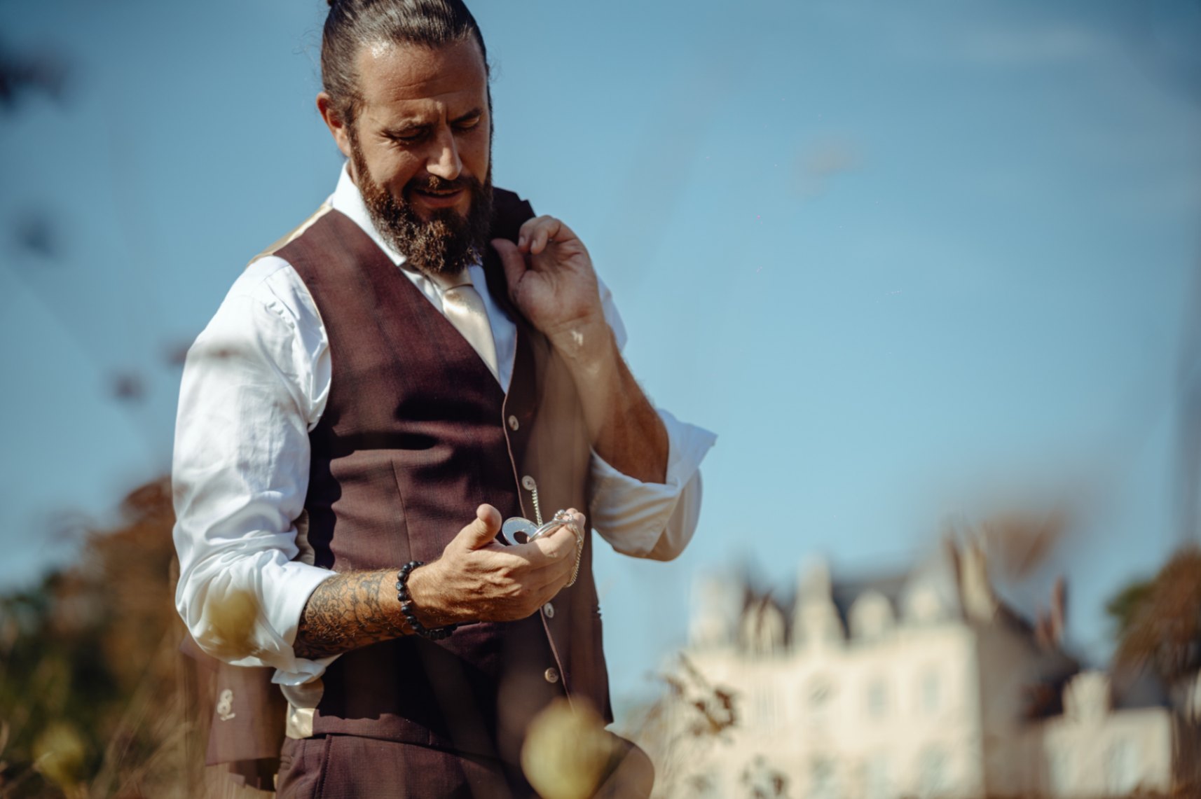 portrait du marié qui consulte l'heure sur sa montre gousset