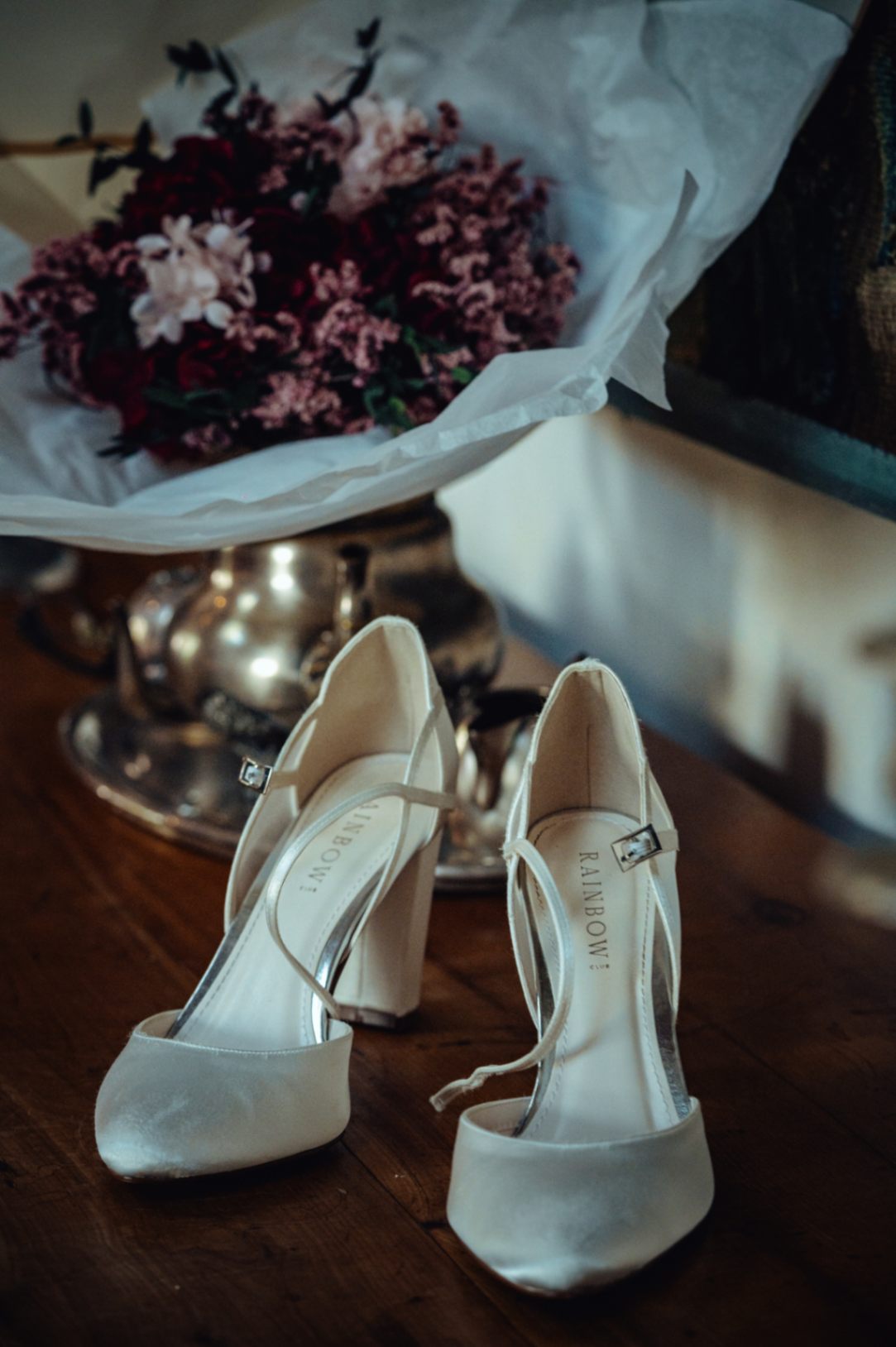 Photo des chaussures à talons et du bouquet de fleurs de la mariée